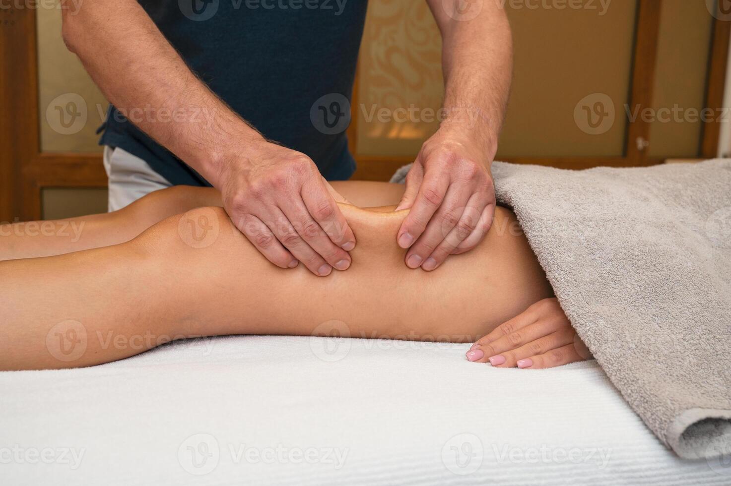 Woman getting legs massage in spa salon photo