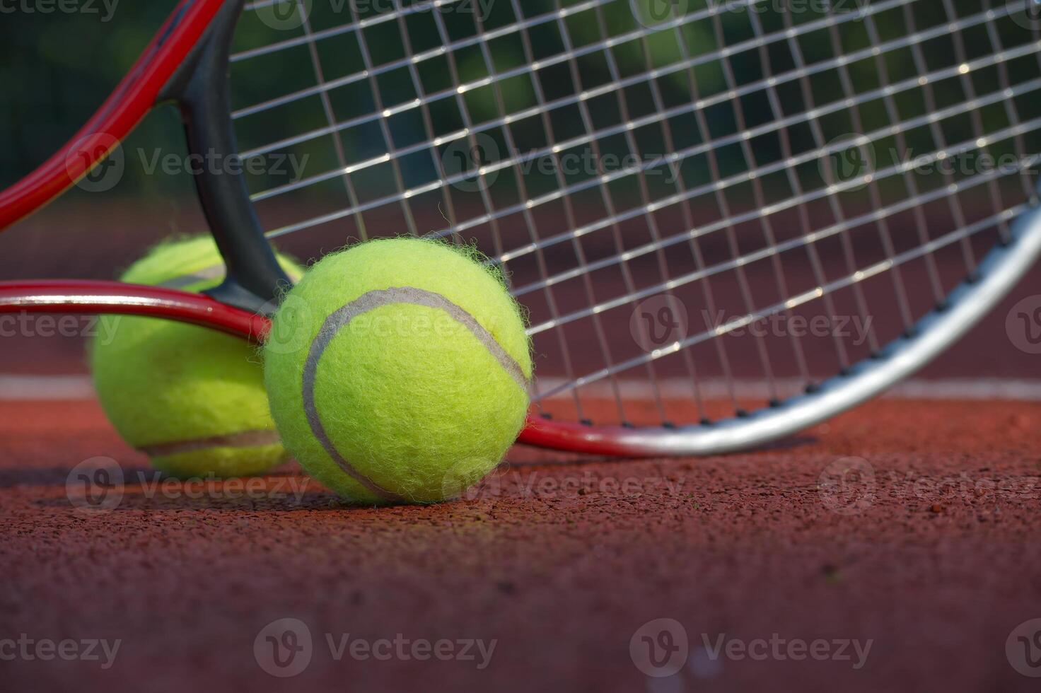 Close-up of tennis ball and racket against net on clay court photo