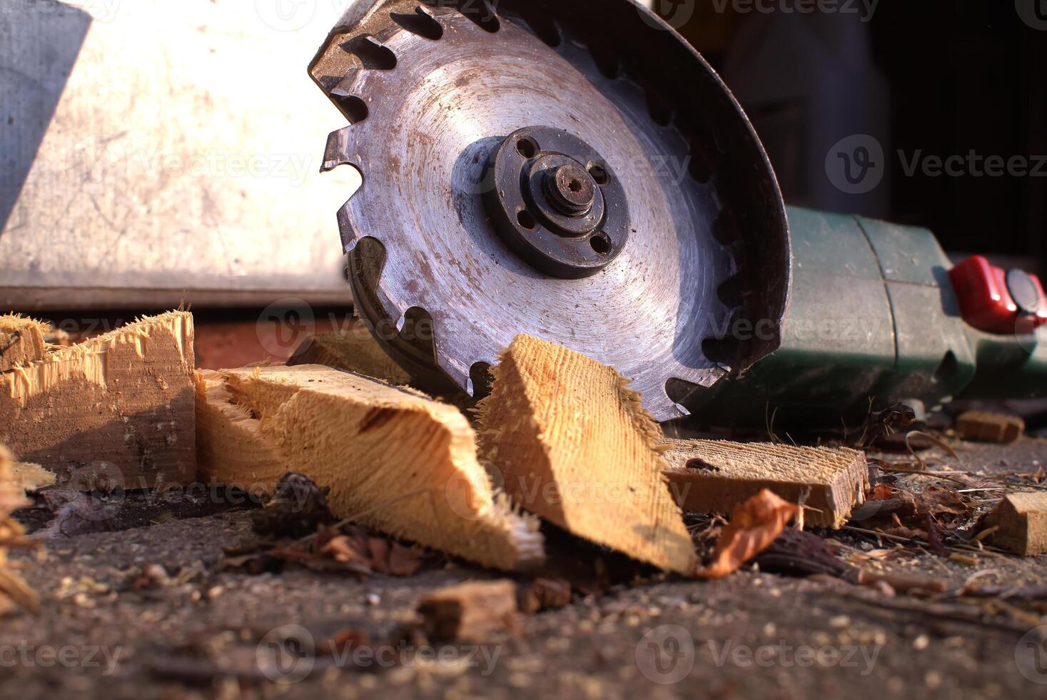 Circular saw blade cutting through logs with wood shavings and debris in a rustic workshop setting photo