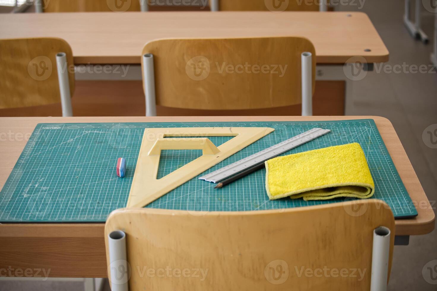 Classroom desk with math tools, ruler, and eraser on a cutting mat photo