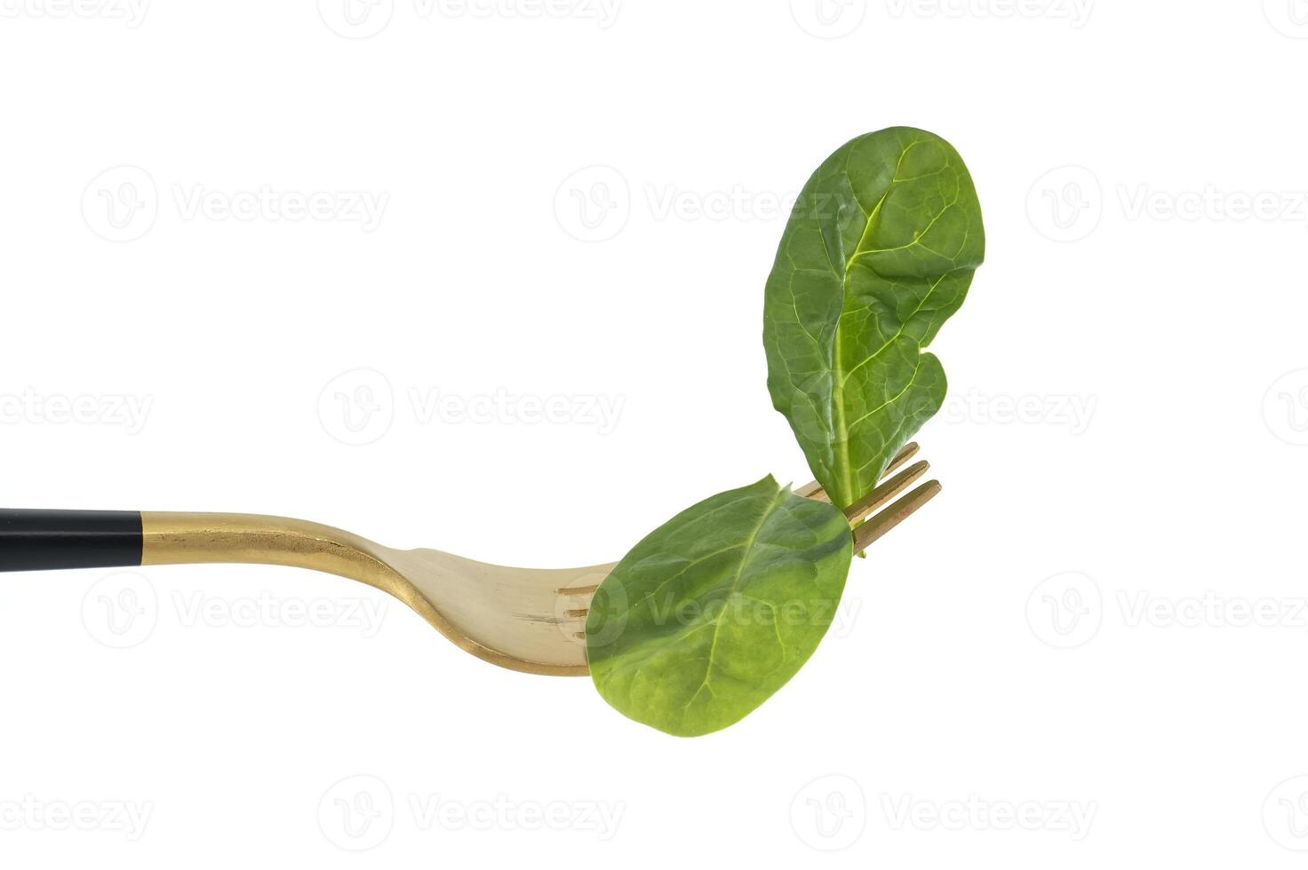 Fresh spinach leaves on gold fork isolated on white background photo