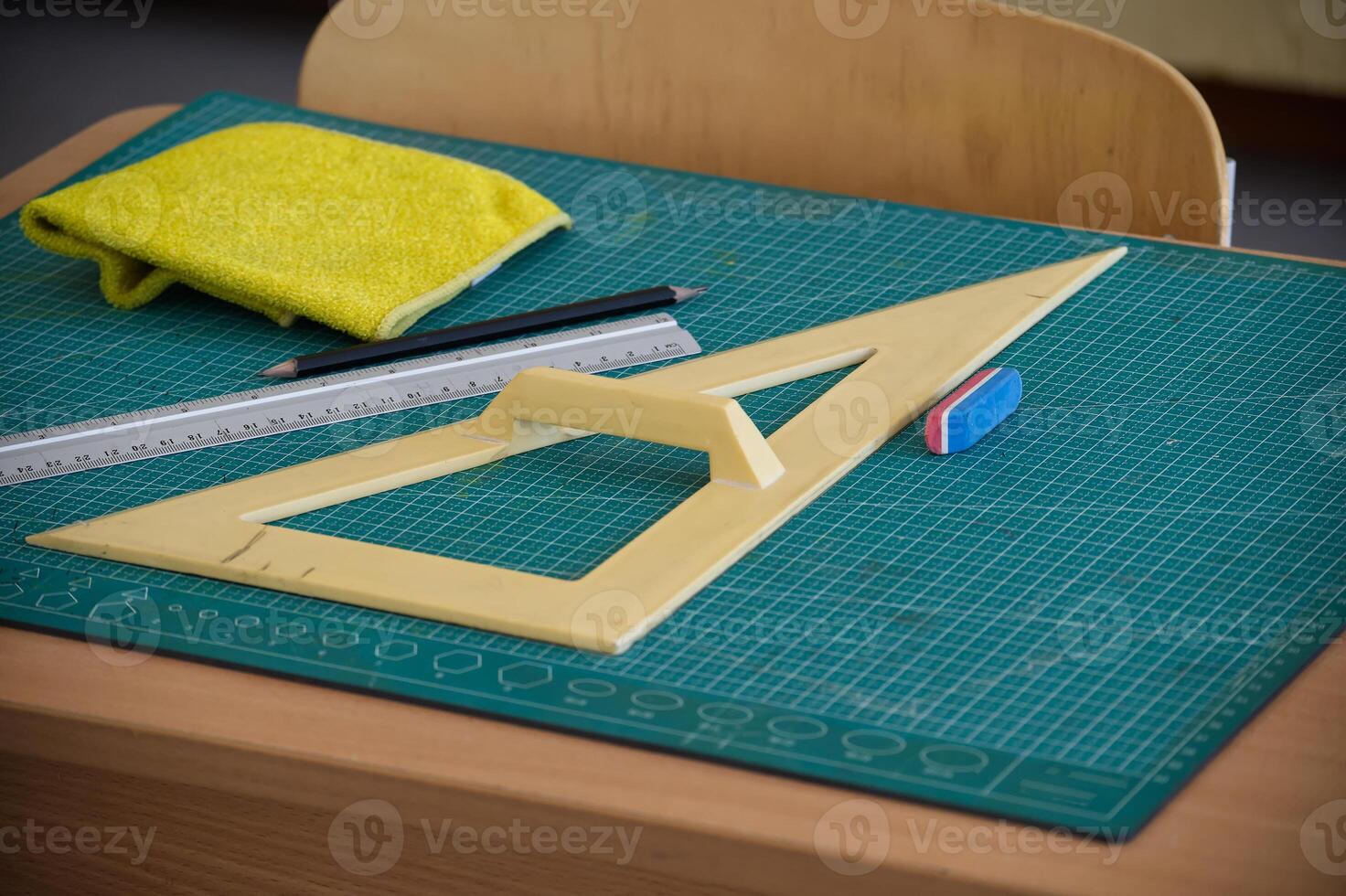 Classroom desk with math tools, ruler, and eraser on a cutting mat photo