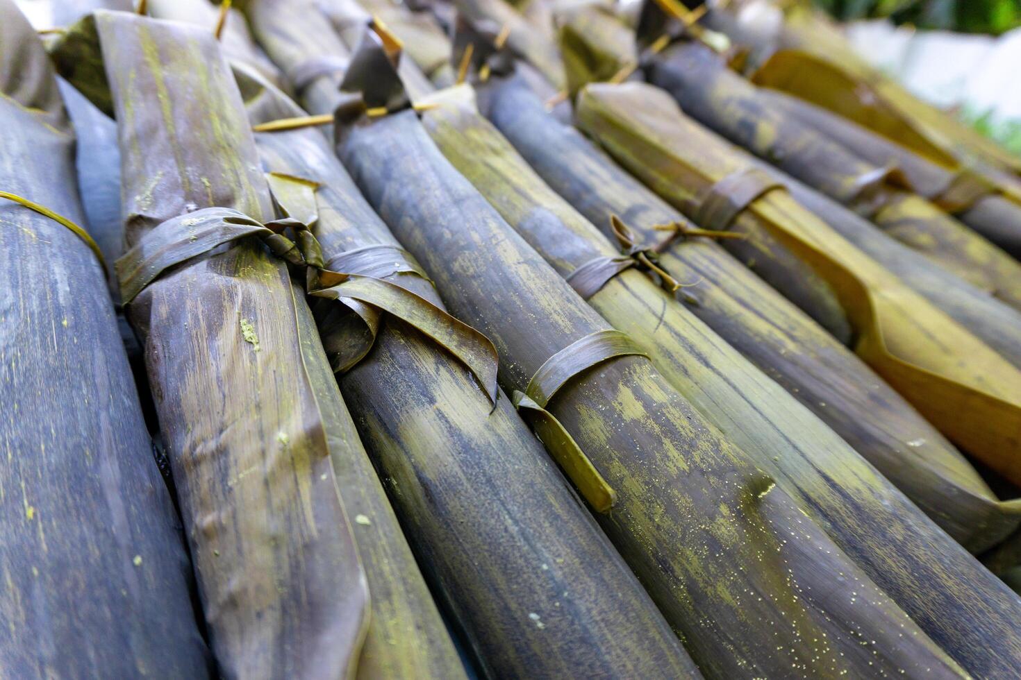 Close up of cylindrical rice cake cooked with banana leaves. Indonesian traditional food called Lontong or Ketupat. Rice rolled in banana leaves and boiled. photo
