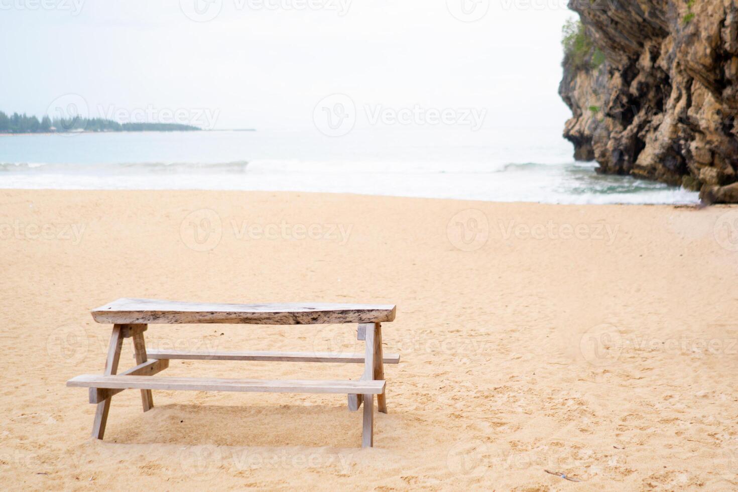 Empty wooden table with benches on the sandy beach. Picnic table at Tebing beach in Aceh Besar, Indonesia photo