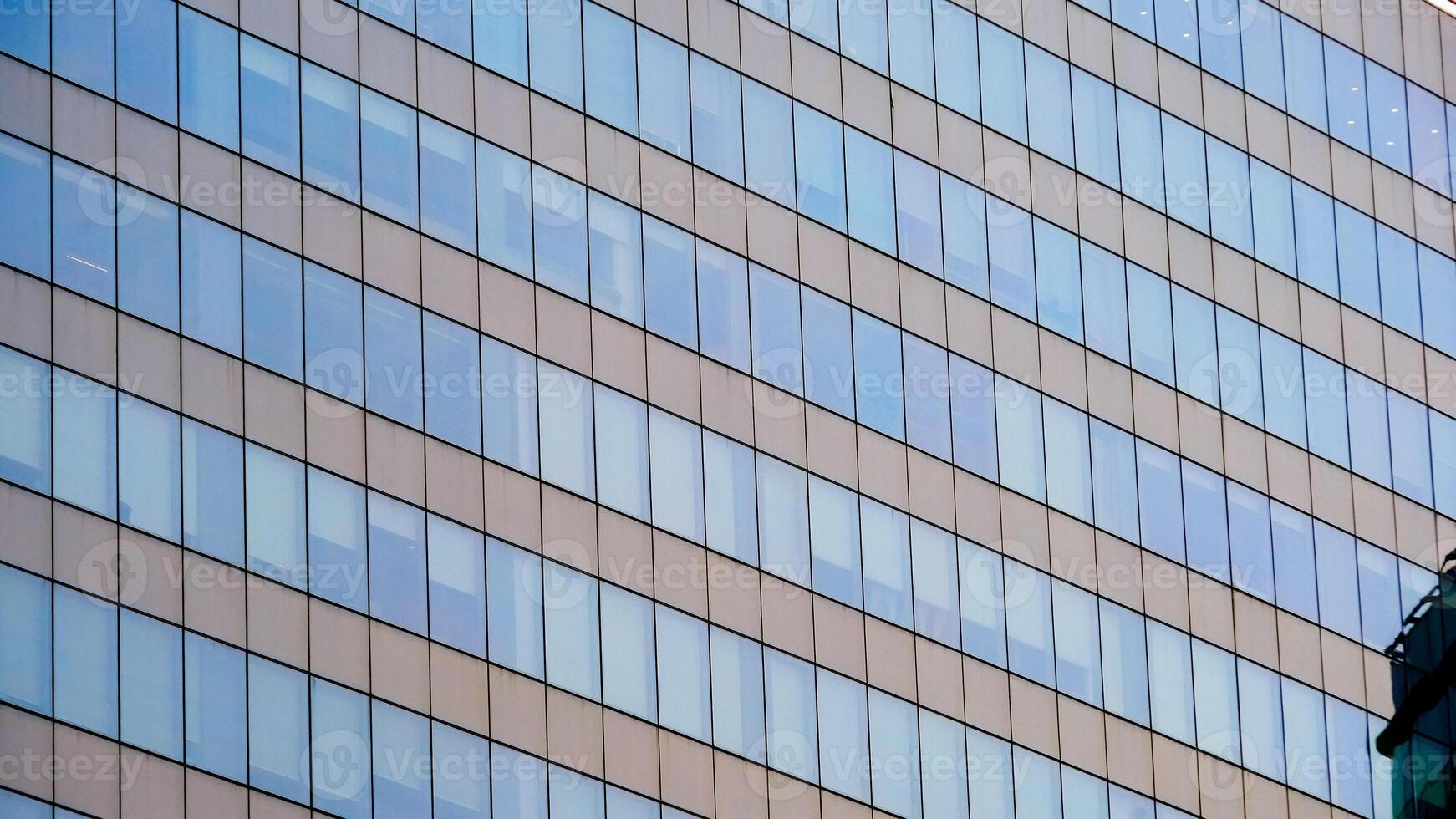 Modern Office Building with Glass Windows Reflecting the Sky in an Urban Setting photo