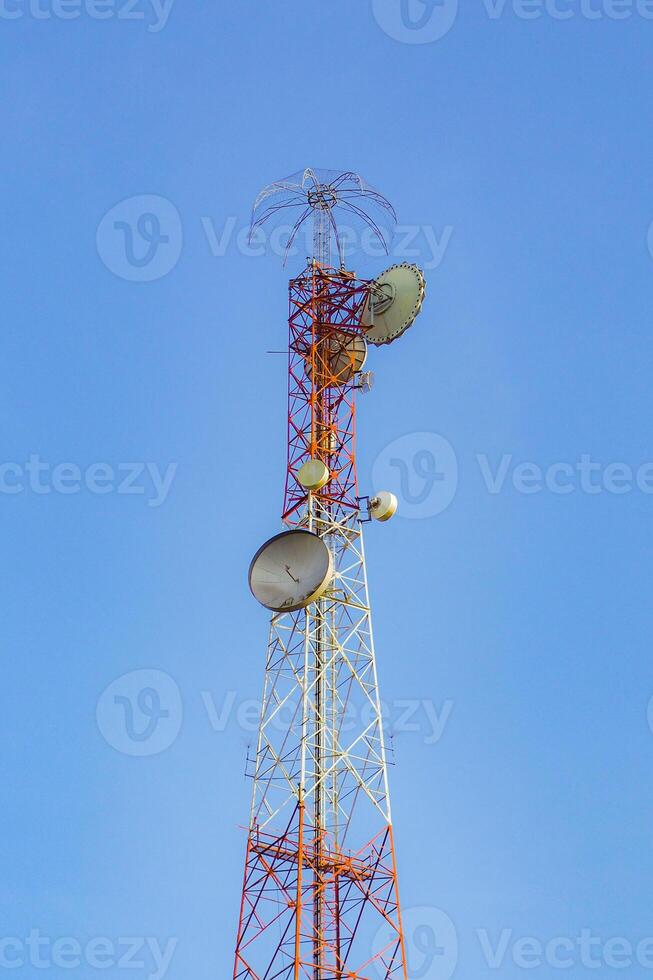 Tall Communication Tower Against Clear Blue Sky with Satellite Dishes and Antennas for Telecommunication and Broadcasting photo