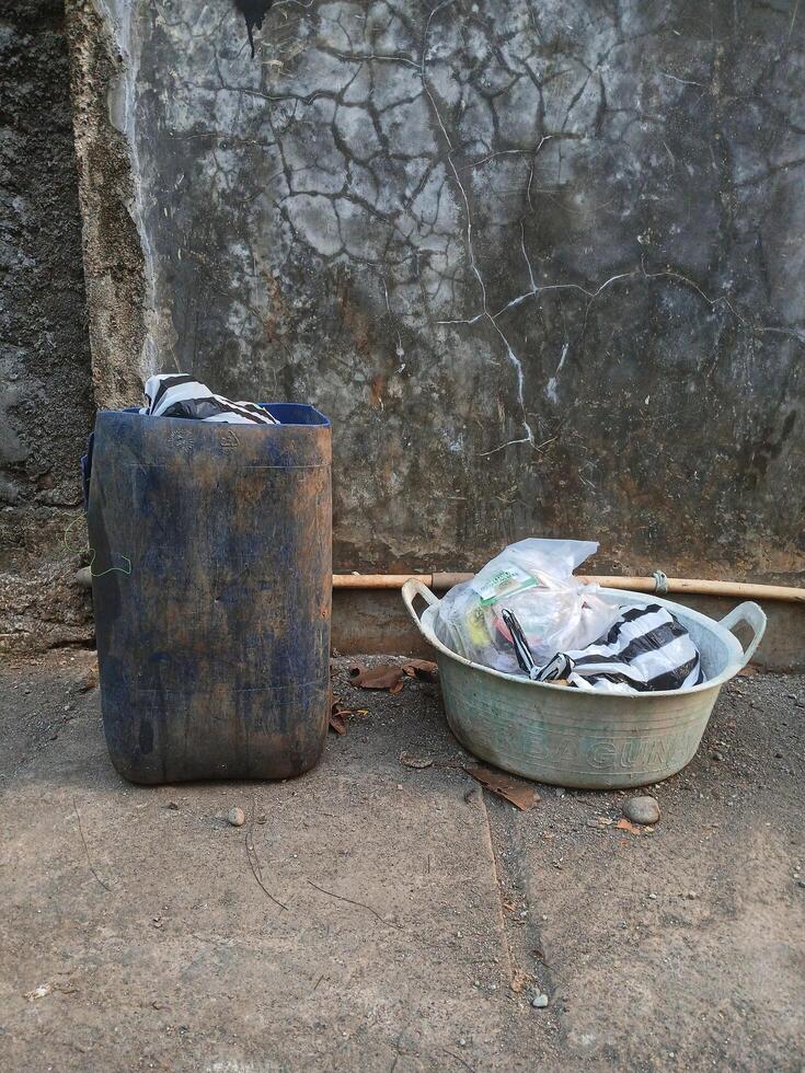 a bucket and a trash can sitting on the ground photo