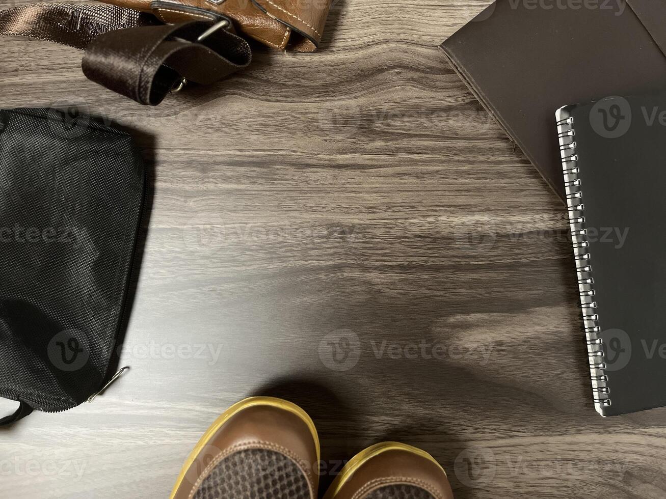 Leather bag with gadgets and notebooks on Wooden Work Desk photo