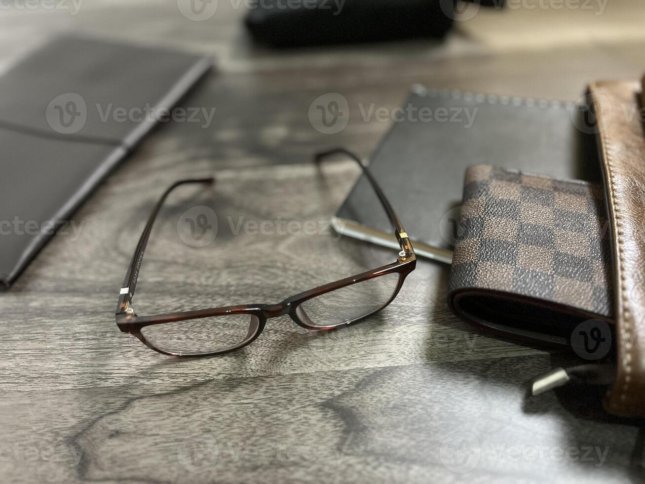 Leather bag with gadgets and notebooks on Wooden Work Desk photo