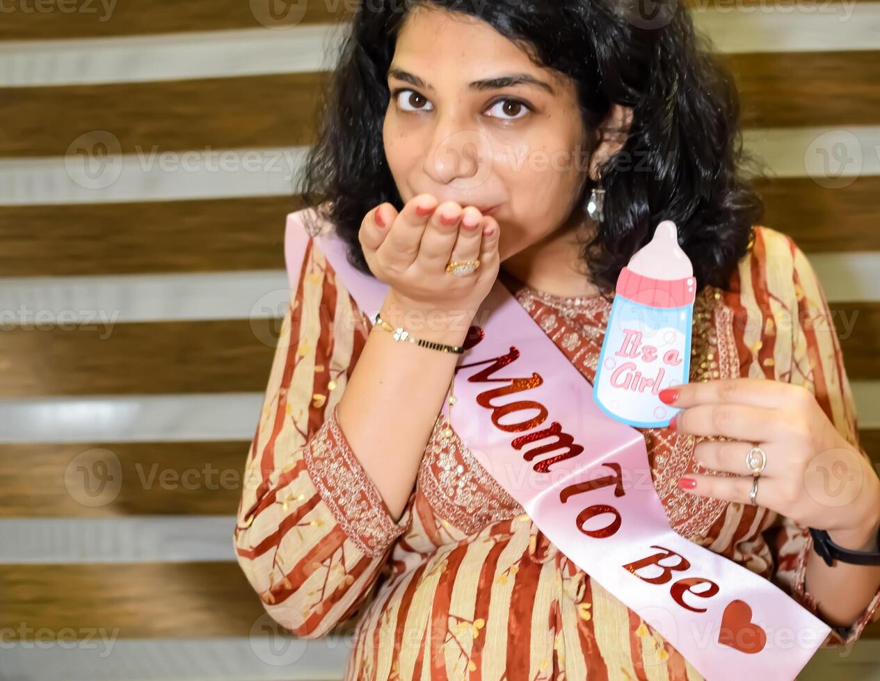 A pregnant Indian lady poses for outdoor pregnancy shoot and hands on belly, Indian pregnant woman puts her hand on her stomach with a maternity dress at society park, Pregnant outside maternity shoot photo