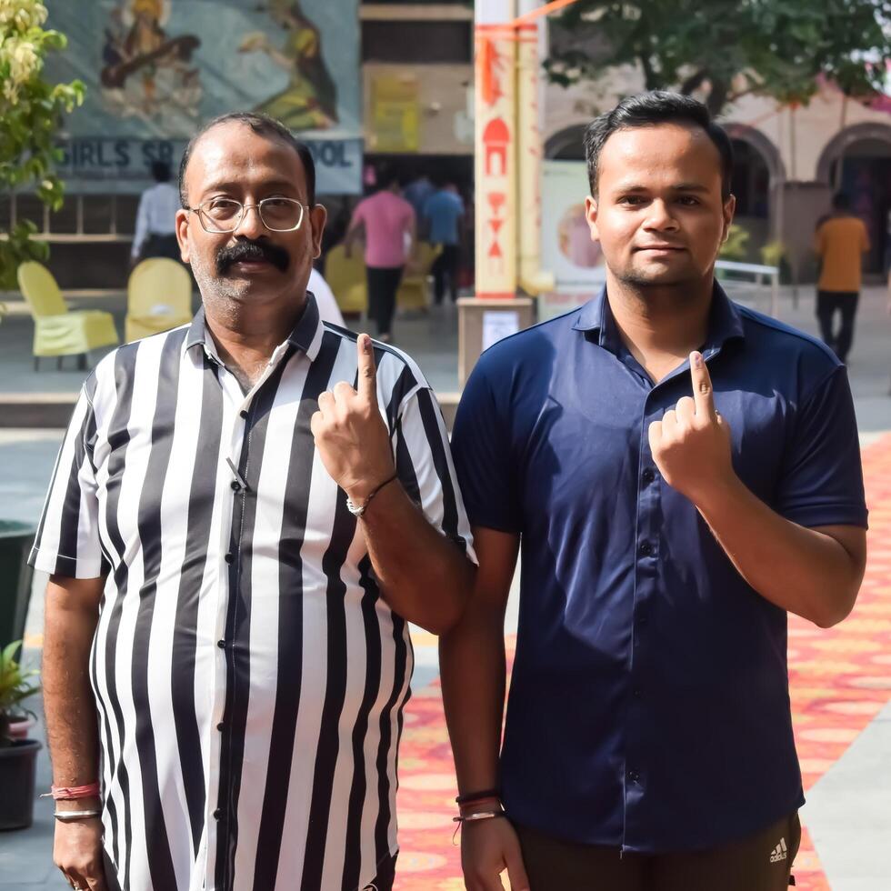 New Delhi, India - May 25 2024 - Unidentified people showing their ink-marked fingers after casting votes in front of polling booth of east Delhi area for general Lok Sabha Elections 2024 photo