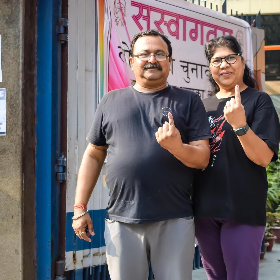 New Delhi, India - May 25 2024 - Unidentified people showing their ink-marked fingers after casting votes in front of polling booth of east Delhi area for general Lok Sabha Elections 2024 photo