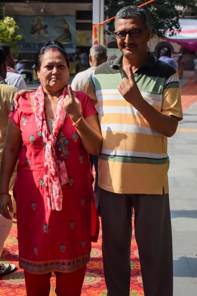 New Delhi, India - May 25 2024 - Unidentified people showing their ink-marked fingers after casting votes in front of polling booth of east Delhi area for general Lok Sabha Elections 2024 photo