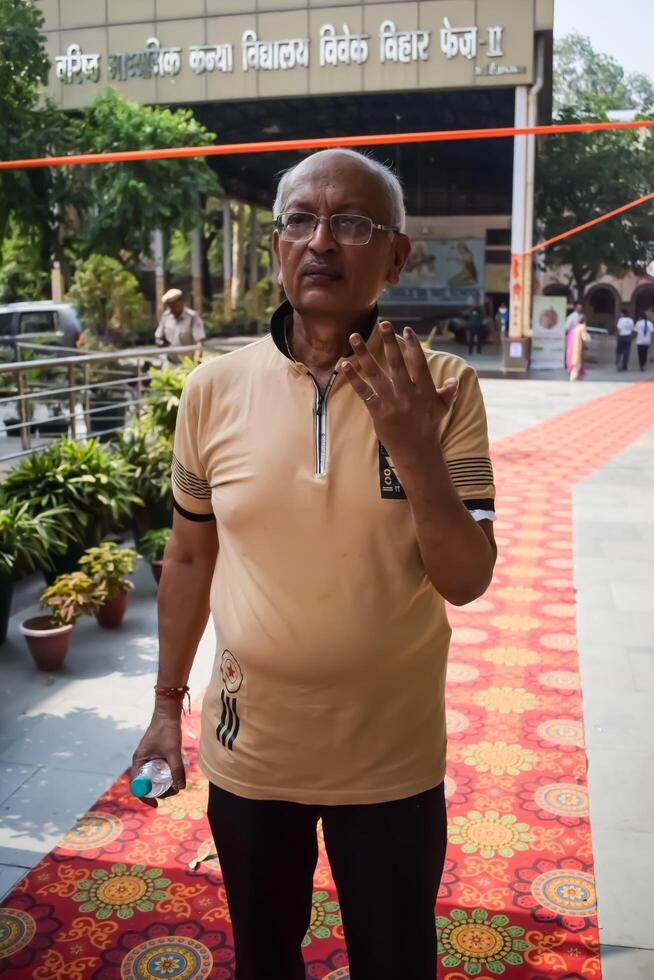 New Delhi, India - May 25 2024 - Unidentified people showing their ink-marked fingers after casting votes in front of polling booth of east Delhi area for general Lok Sabha Elections 2024 photo