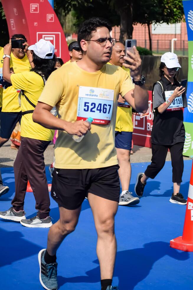 New Delhi, India - July 15 2024 - Vedanta Delhi Half Marathon race after covid in which marathon participants about to cross the finish line, Delhi Half Marathon 2023 photo