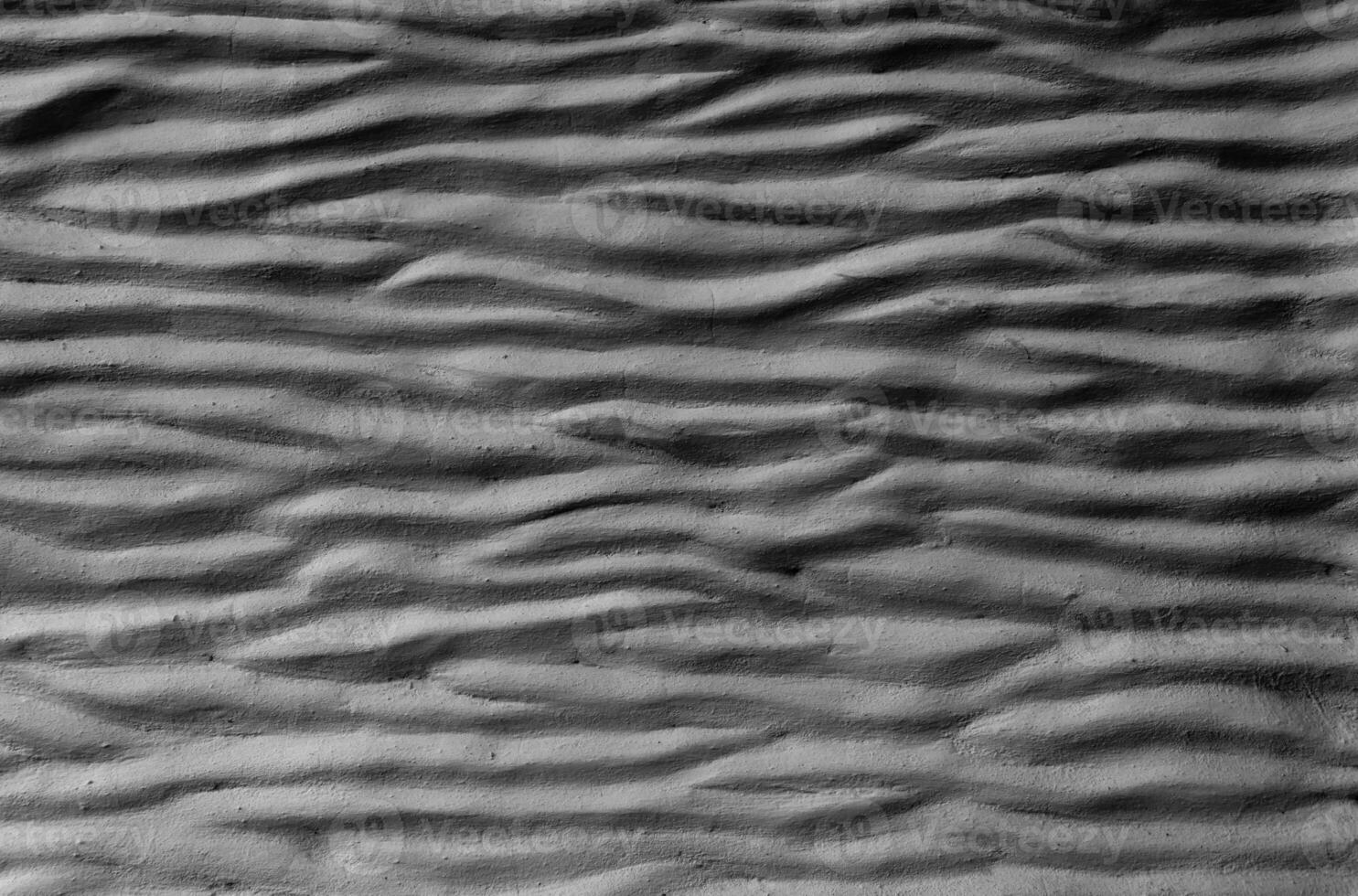 black cement wall curved with wave pattern. Modern design of black wavy background photo