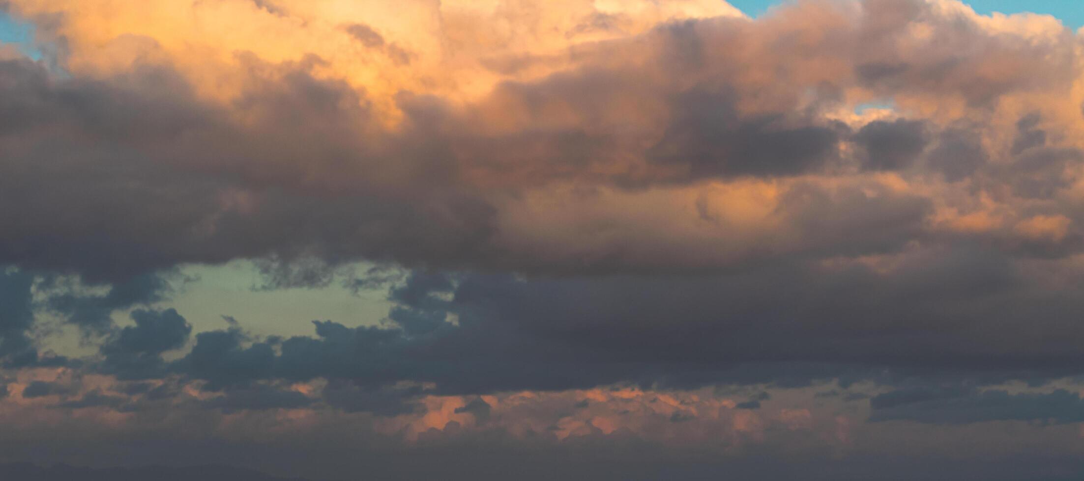 Dramatic clouds in the blue sky in the morning, the rising sun rays hitting the clouds photo