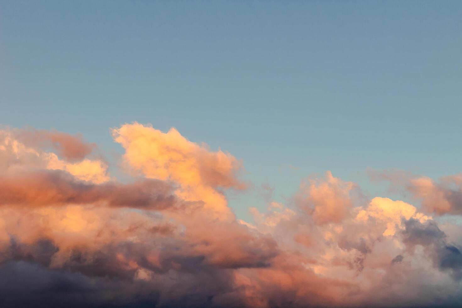 Dramatic clouds in the blue sky in the morning, the rising sun rays hitting the clouds photo