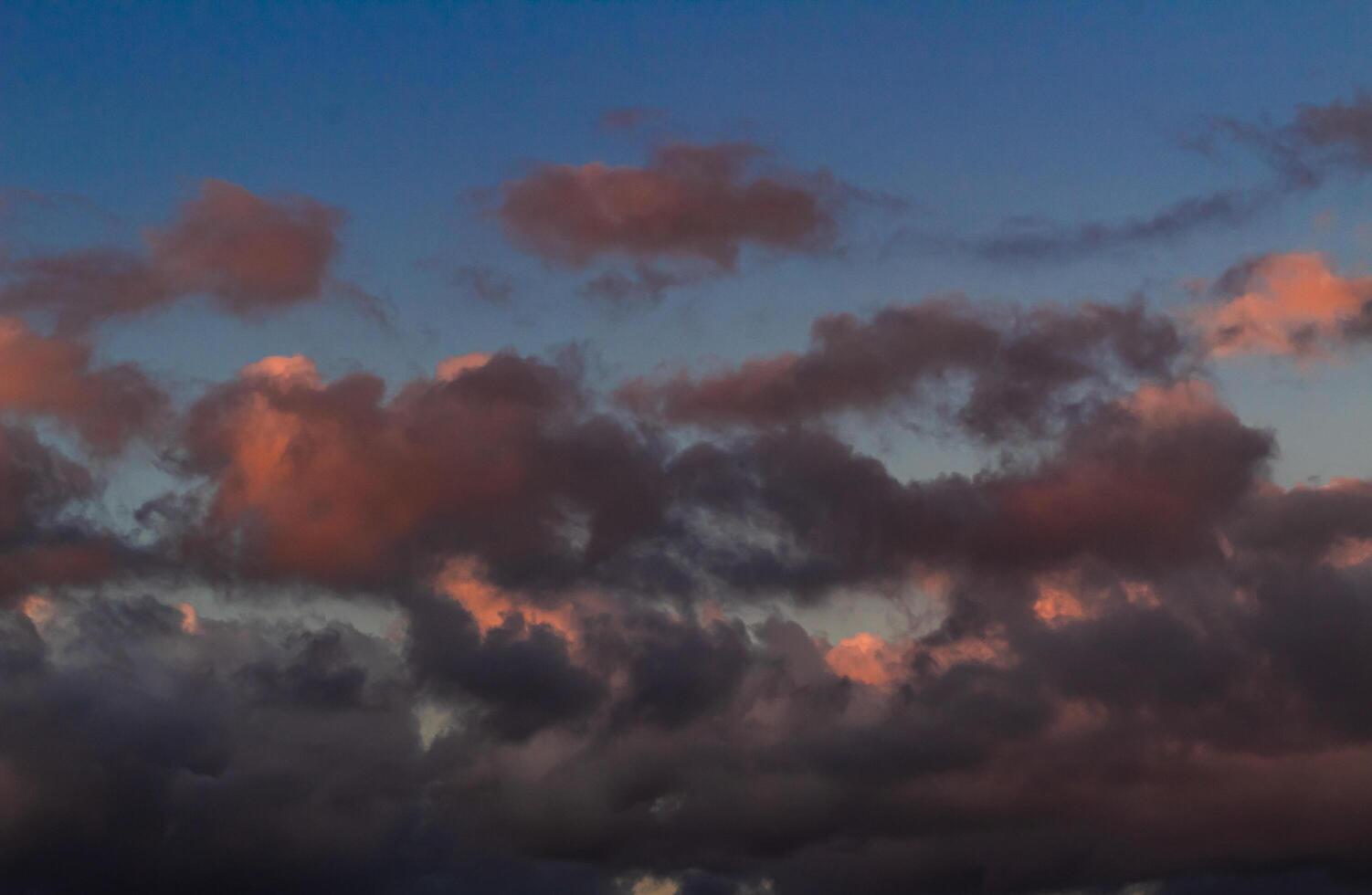 Dramatic clouds in the blue sky in the morning, the rising sun rays hitting the clouds photo