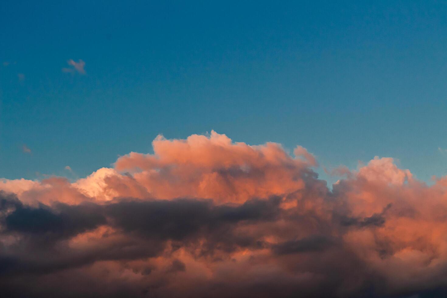 Dramatic clouds in the blue sky in the morning, the rising sun rays hitting the clouds photo
