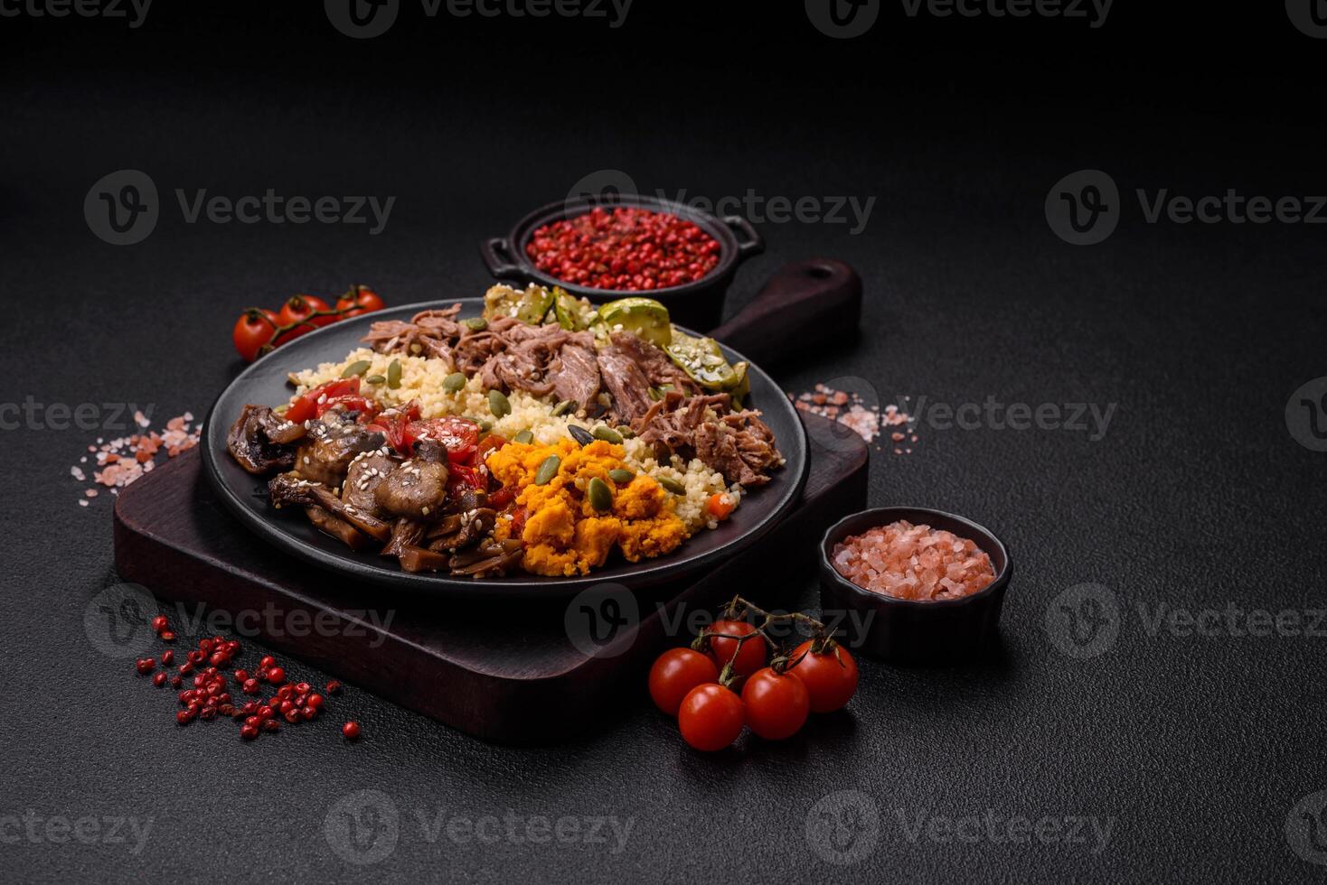 Bowl of food with beef, bulgur, tomatoes, mushrooms, zucchini photo