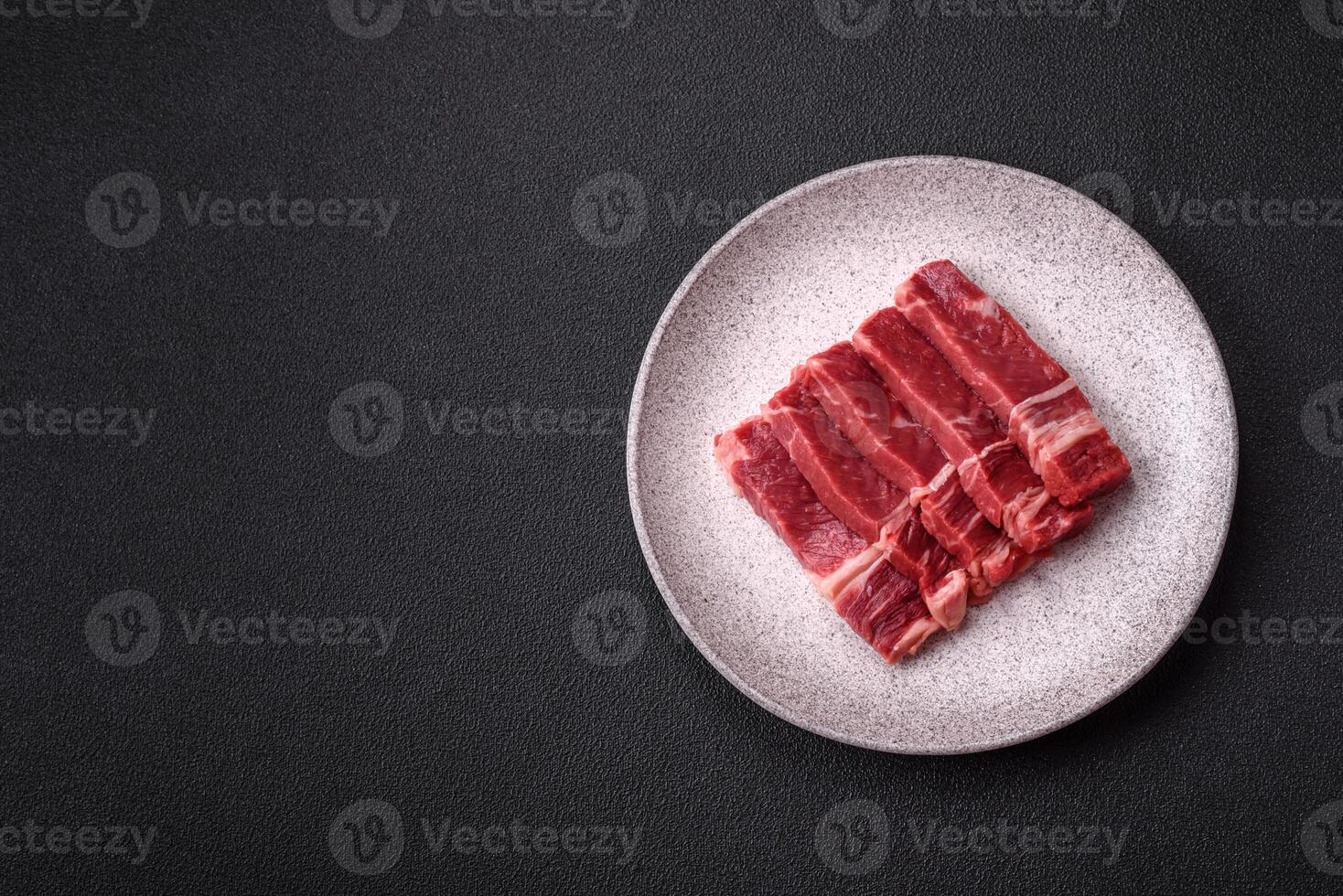Fresh raw beef cut into slices with salt, spices photo