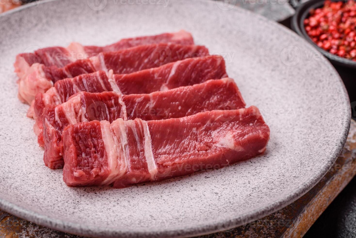 Fresh raw beef cut into slices with salt, spices photo