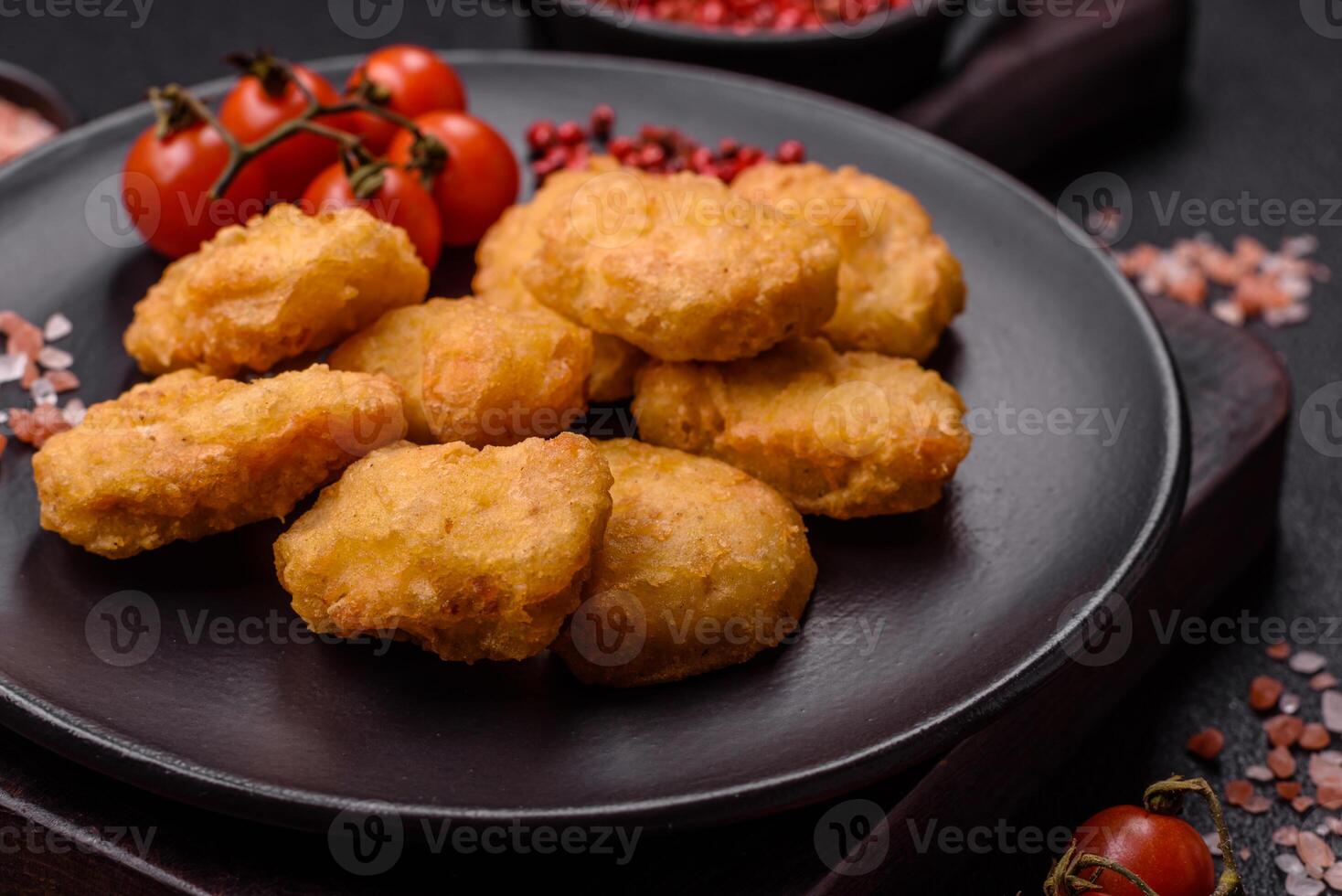 Delicious fresh crispy chicken nuggets on a dark concrete background photo