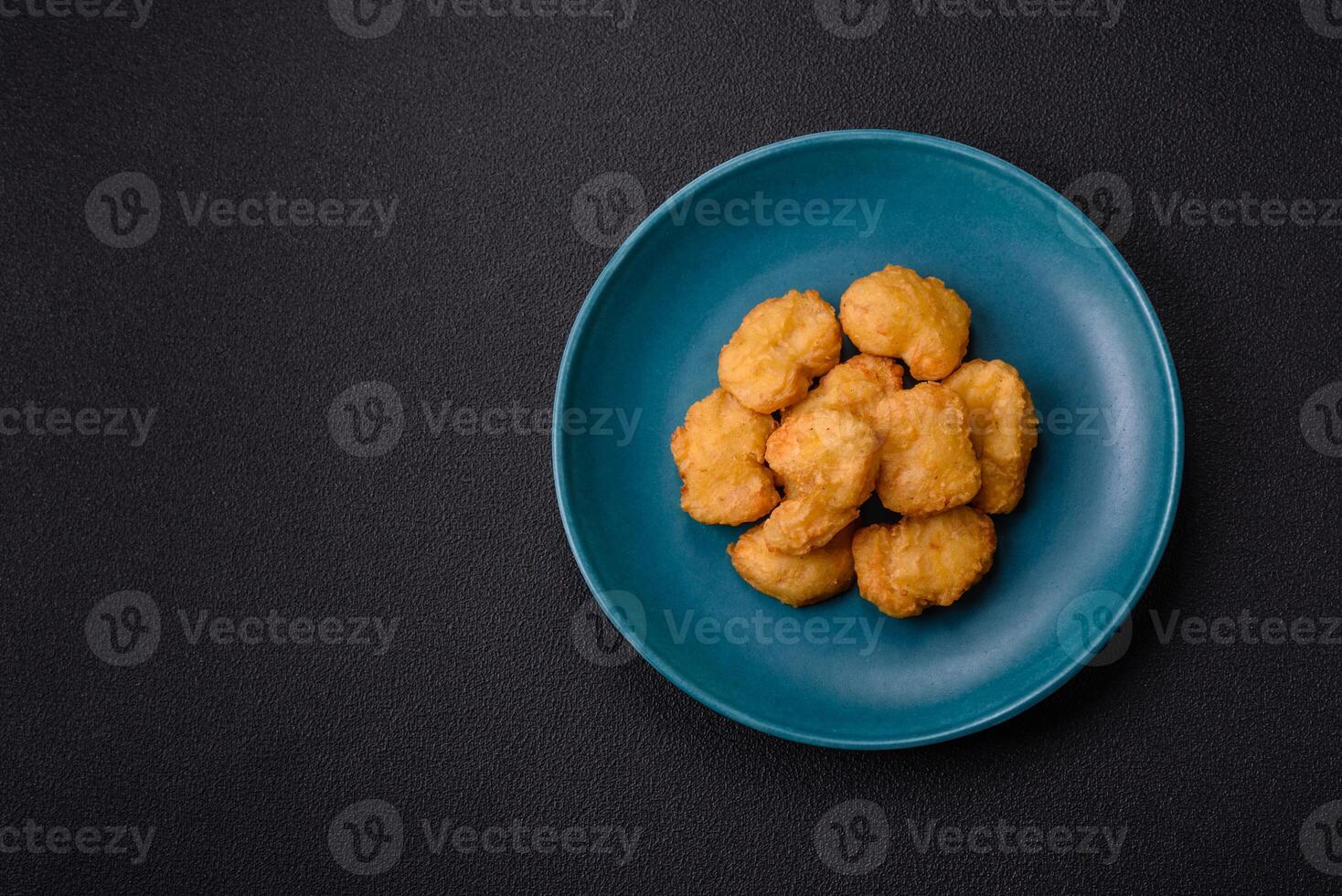 Delicious fresh crispy chicken nuggets on a dark concrete background photo