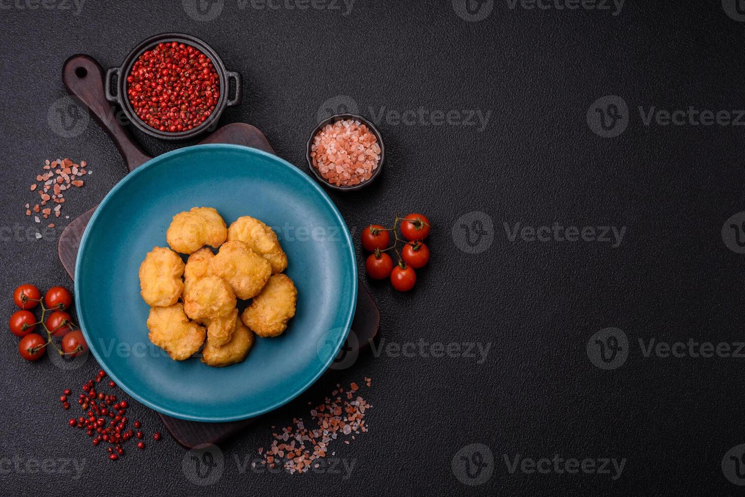 Delicious fresh crispy chicken nuggets on a dark concrete background photo