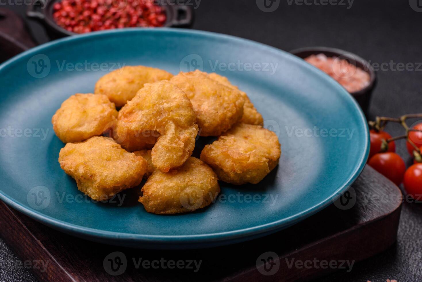 Delicious fresh crispy chicken nuggets on a dark concrete background photo