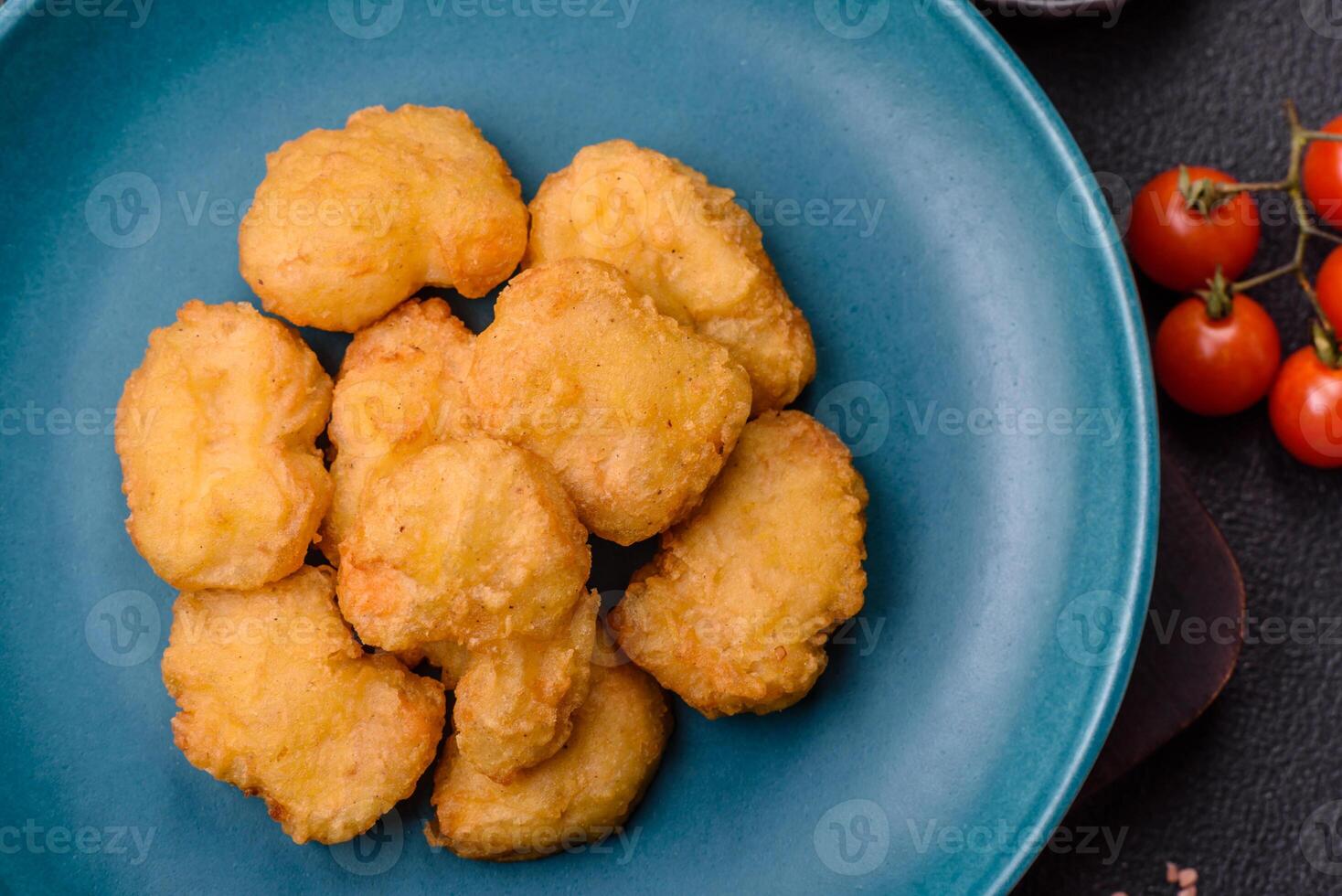 Delicious fresh crispy chicken nuggets on a dark concrete background photo