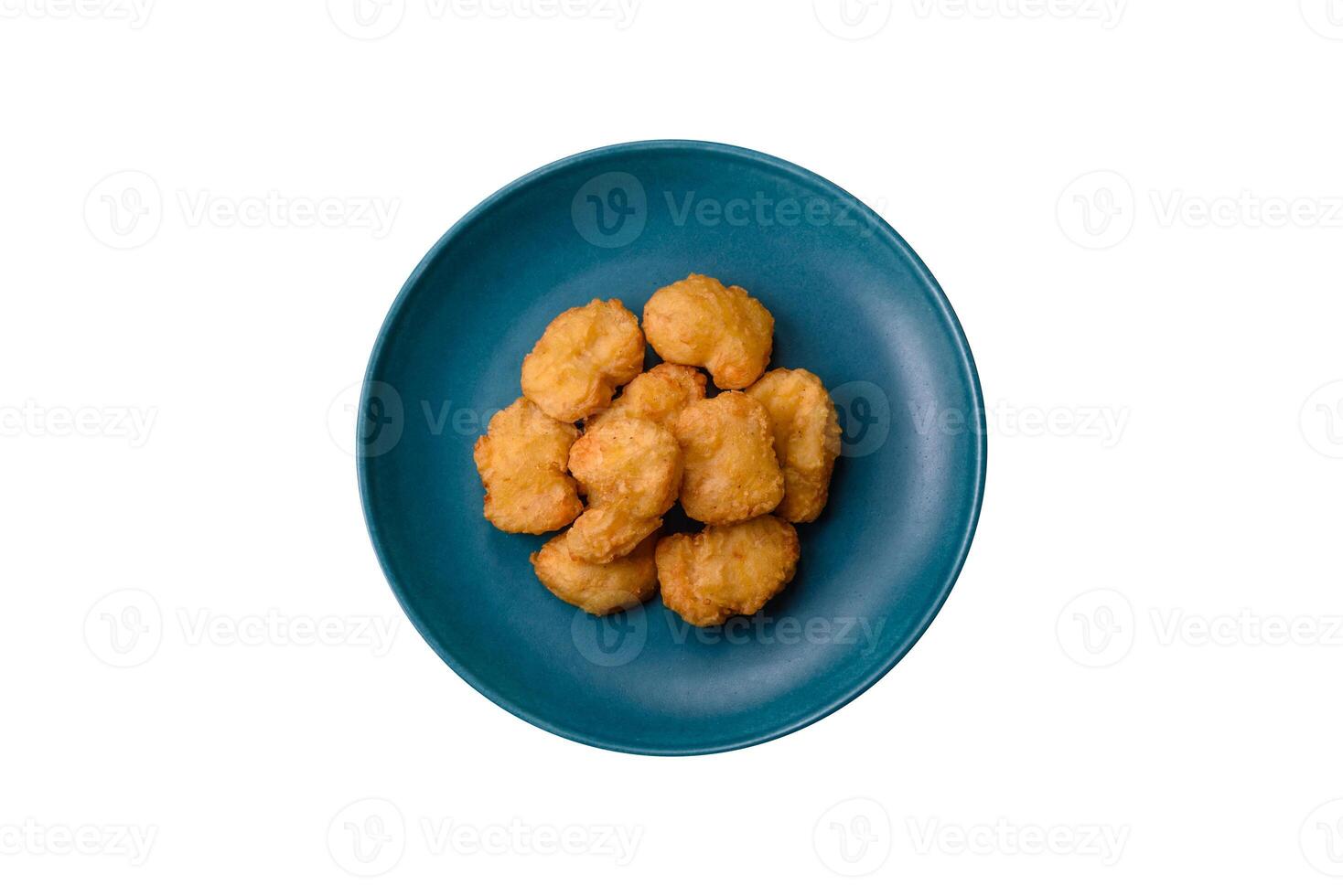 Delicious fresh crispy chicken nuggets on a dark concrete background photo