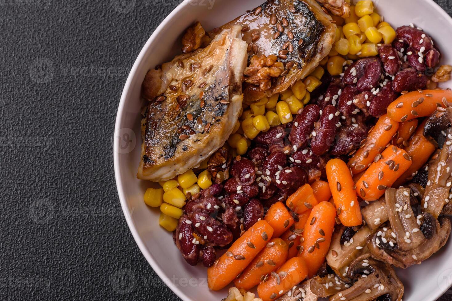 A colorful vegetarian dish consists of fish, beans, corn, mushrooms photo