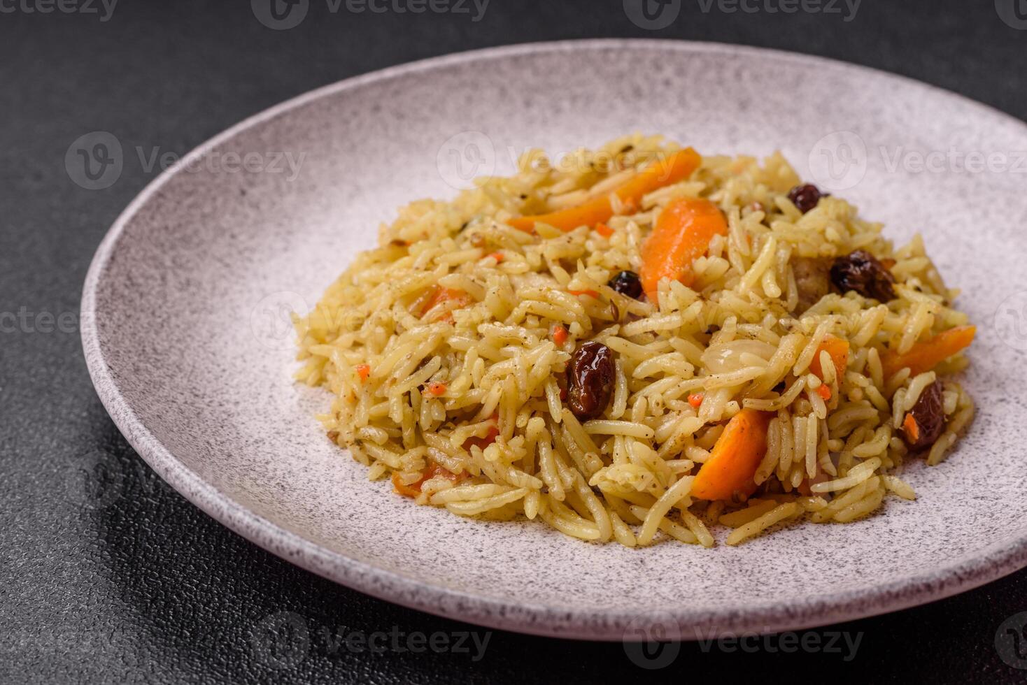 Delicious fresh pilaf with rice, carrots, meat, onions, spices and berries photo