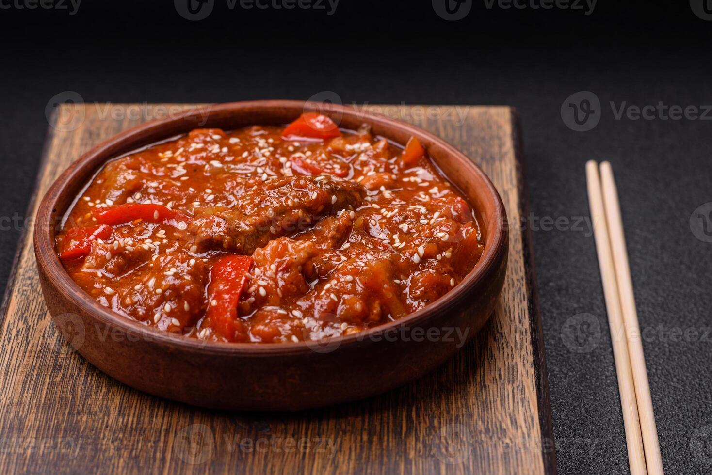 Thai Asian dish with meat, hot pepper, tomato sauce and sesame photo