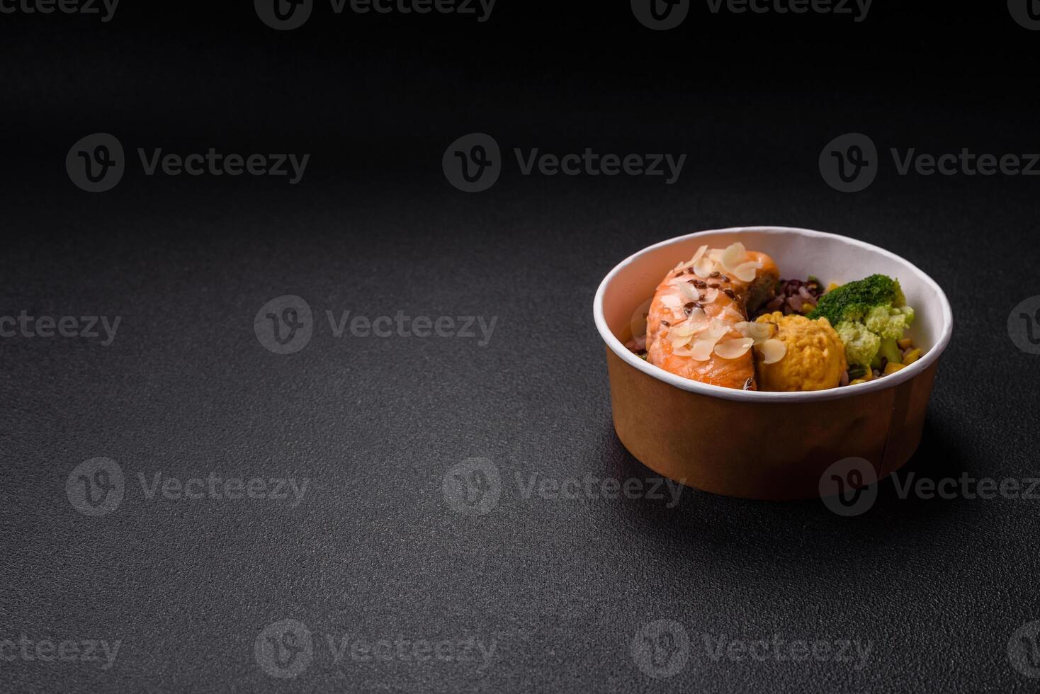 A piece of boiled salmon with rice, broccoli, salt and spices photo