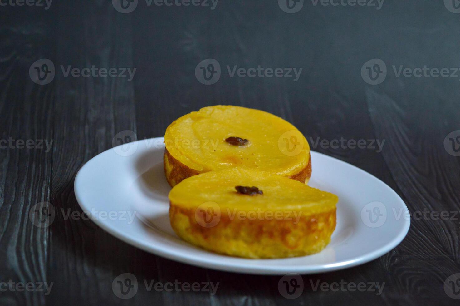 Mud cake is a traditional Indonesian cake, made from potatoes, flour, sugar, eggs and coconut milk and then bake with raisins served on white plate. Selected focus. photo
