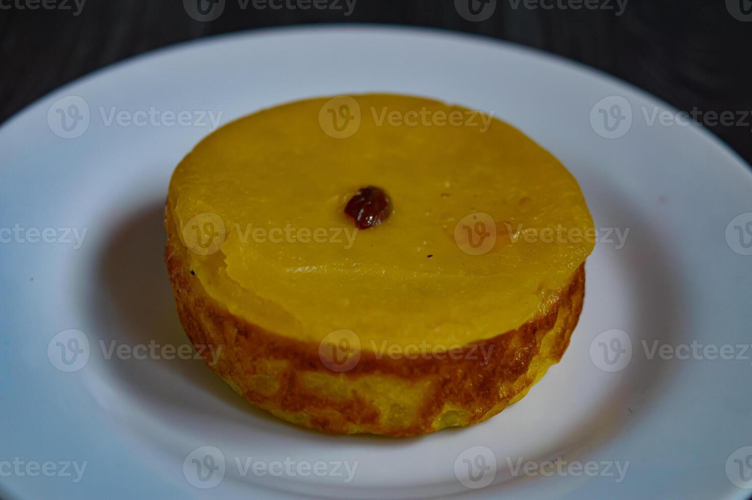 Mud cake is a traditional Indonesian cake, made from potatoes, flour, sugar, eggs and coconut milk and then bake with raisins served on white plate. Selected focus. photo