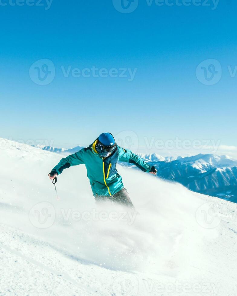 Close up vertical banner male skier on piste ski downhill extreme stops pull breaks fast motion in Alps. Active winter holidays, skiing downhill in overcast day. Ski rides on the track with swirls photo
