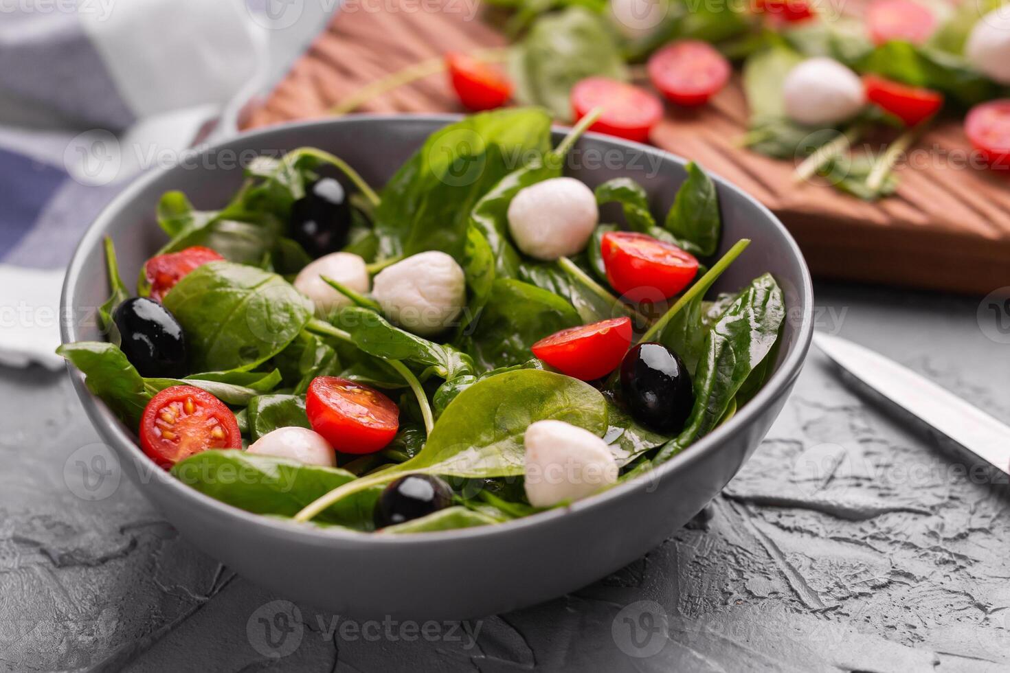 Fresh salad with mozzarella cheese, tomato, spinach close-up. Healthy food. photo