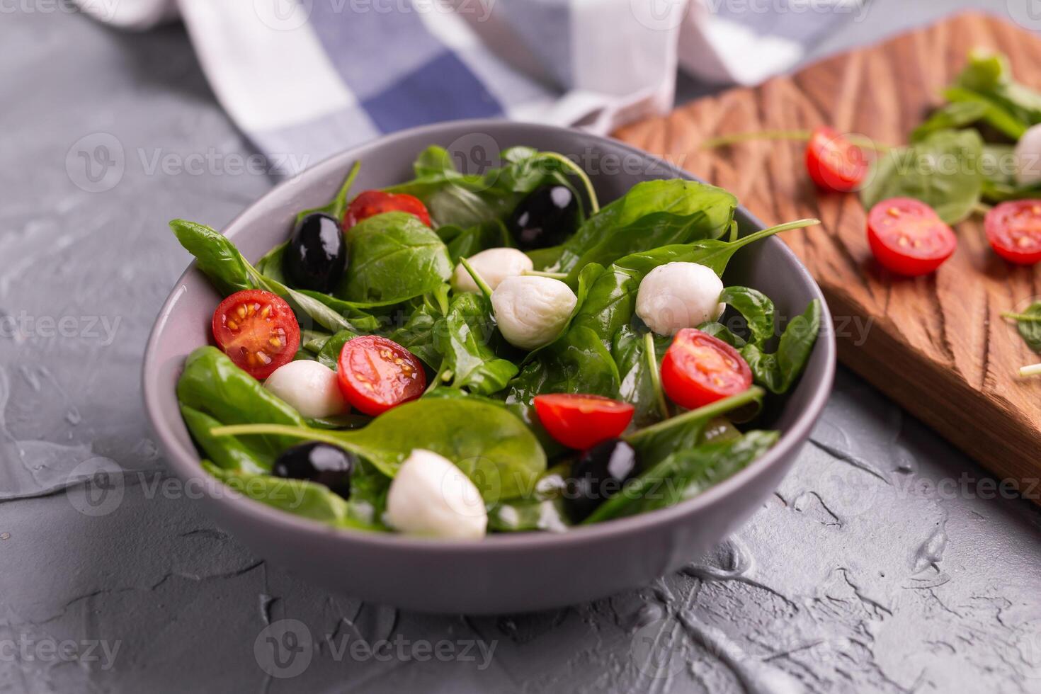 Fresh salad with mozzarella cheese, tomato, spinach close-up. Healthy food. photo