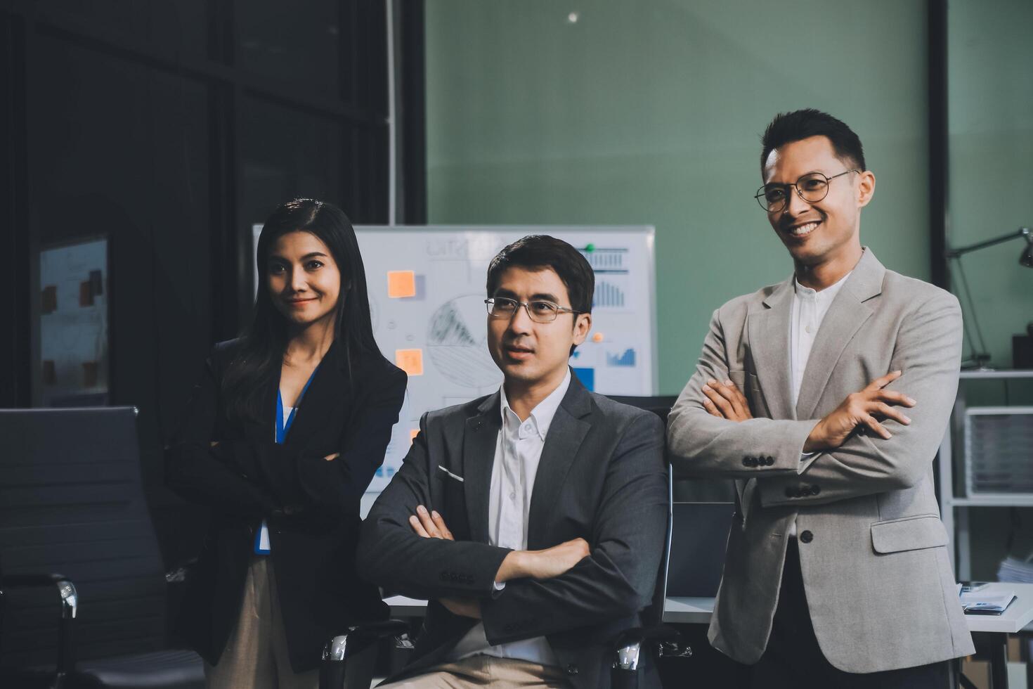 Group of colleagues engaging in a discussion during a business meeting in a conference room. Happy business people, men and women, collaborating and working towards their shared goals. photo