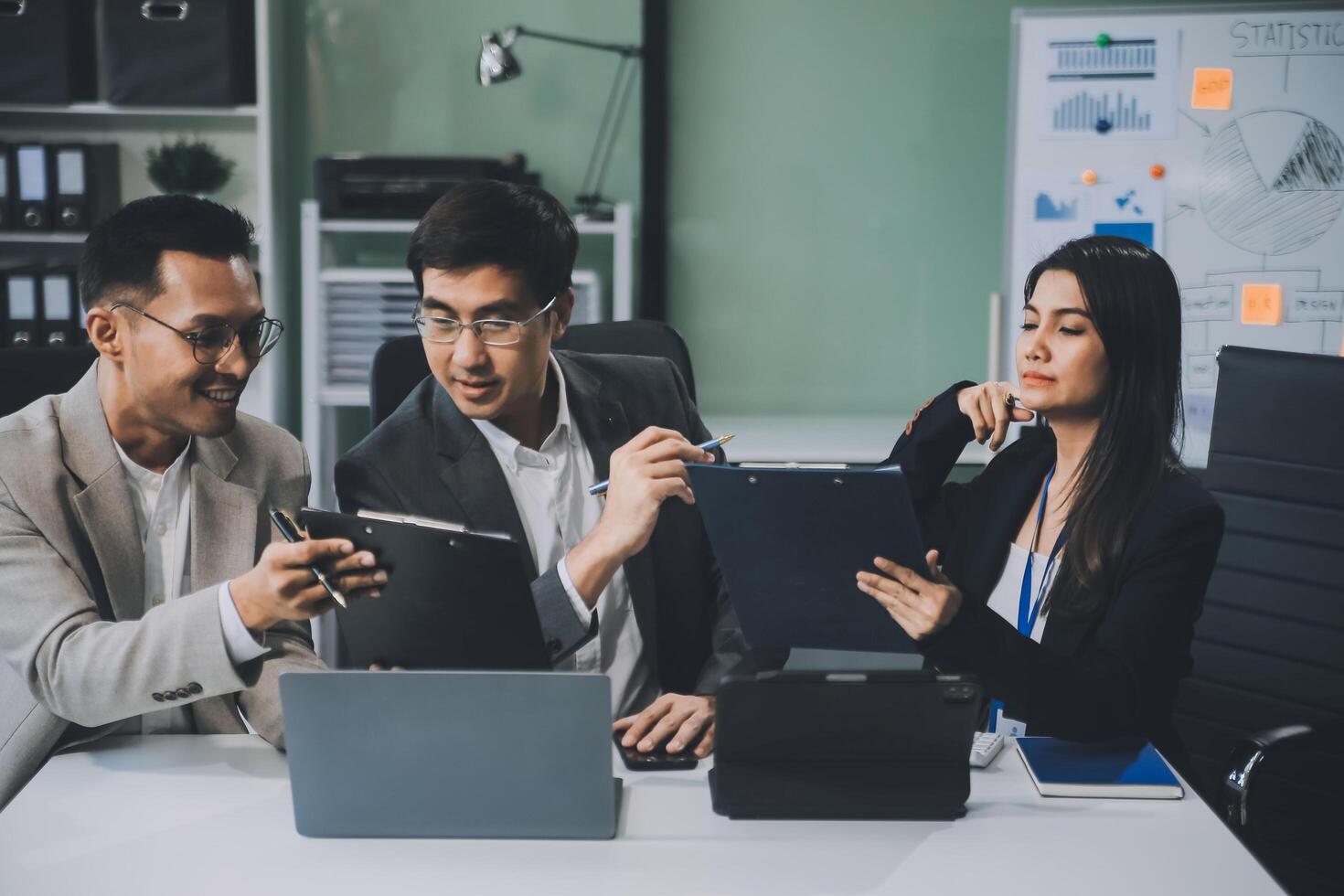 Group of colleagues engaging in a discussion during a business meeting in a conference room. Happy business people, men and women, collaborating and working towards their shared goals. photo