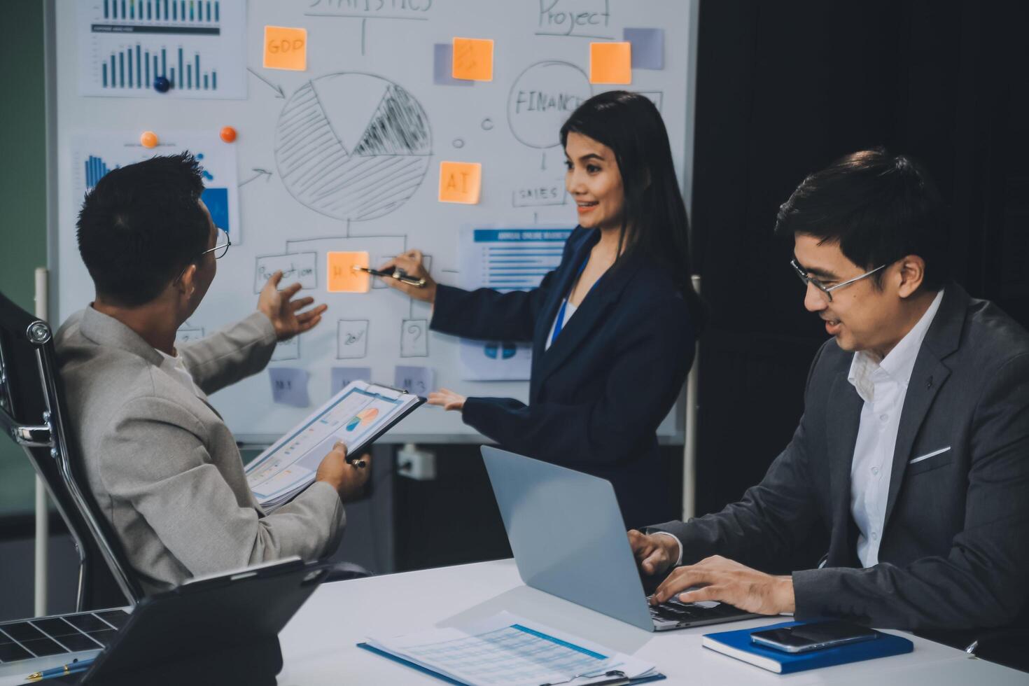 Group of confident business people point to graphs and charts to analyze market data, balance sheet, account, net profit to plan new sales strategies to increase production capacity. photo