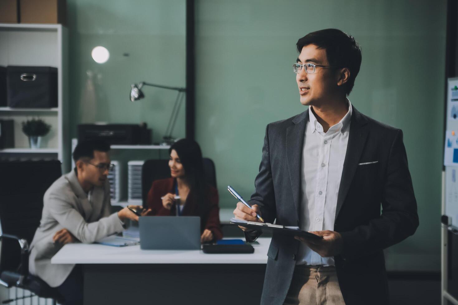 Group of colleagues engaging in a discussion during a business meeting in a conference room. Happy business people, men and women, collaborating and working towards their shared goals. photo