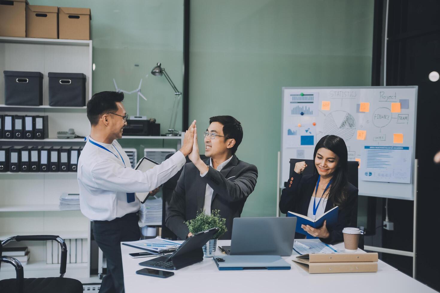 Group of colleagues engaging in a discussion during a business meeting in a conference room. Happy business people, men and women, collaborating and working towards their shared goals. photo