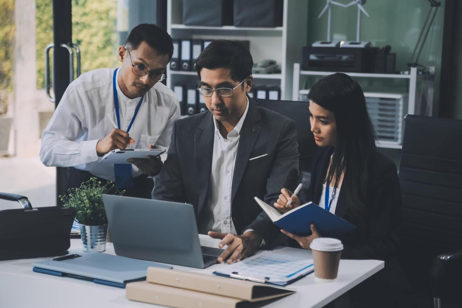 Group of colleagues engaging in a discussion during a business meeting in a conference room. Happy business people, men and women, collaborating and working towards their shared goals. photo