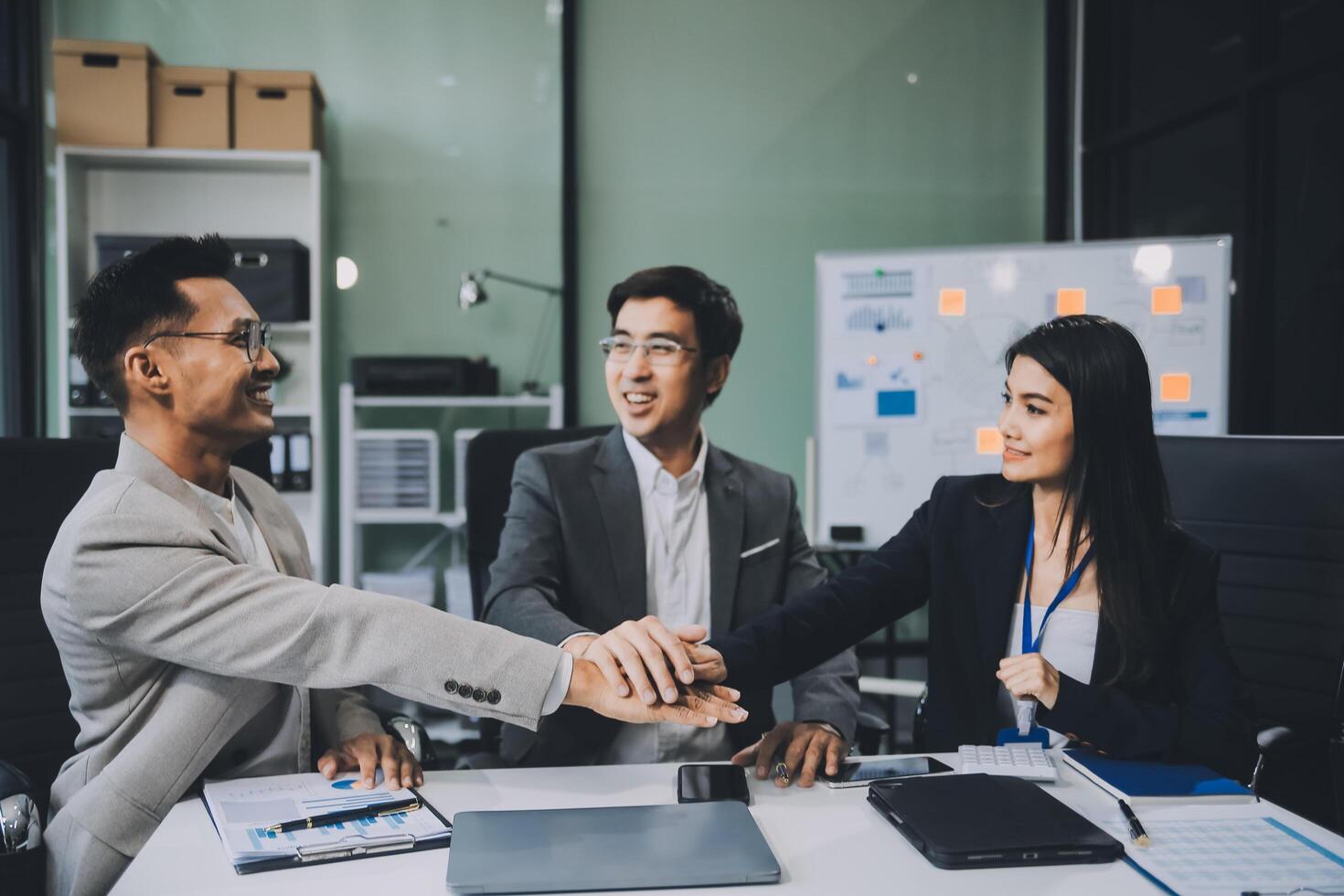 Group of colleagues engaging in a discussion during a business meeting in a conference room. Happy business people, men and women, collaborating and working towards their shared goals. photo