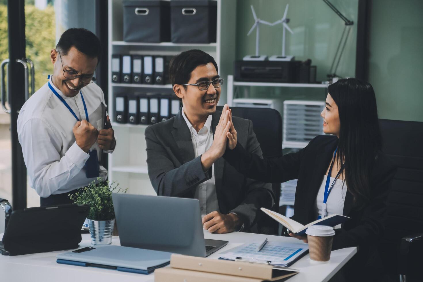 Group of colleagues engaging in a discussion during a business meeting in a conference room. Happy business people, men and women, collaborating and working towards their shared goals. photo